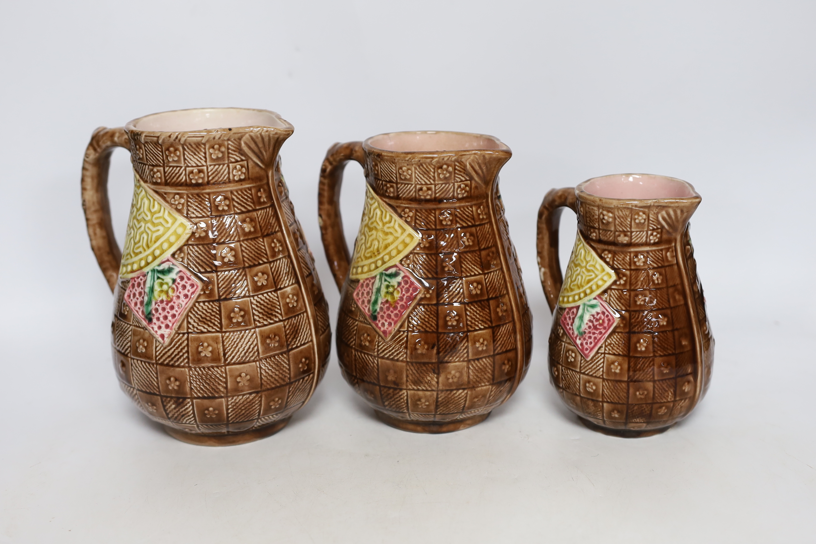 A set of three Aesthetic period graduated majolica jugs, tallest 19.5cm